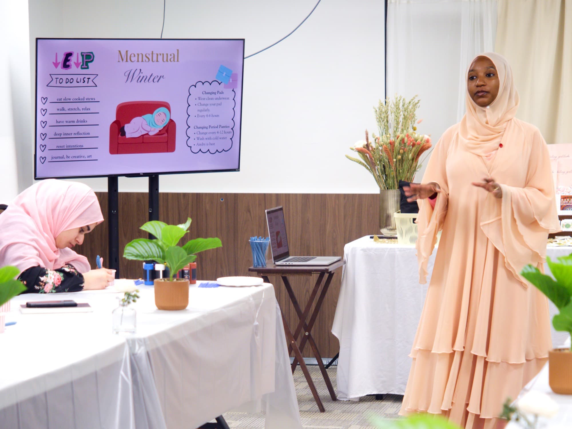 A slide about the menstrual winter phase beside the presenter
