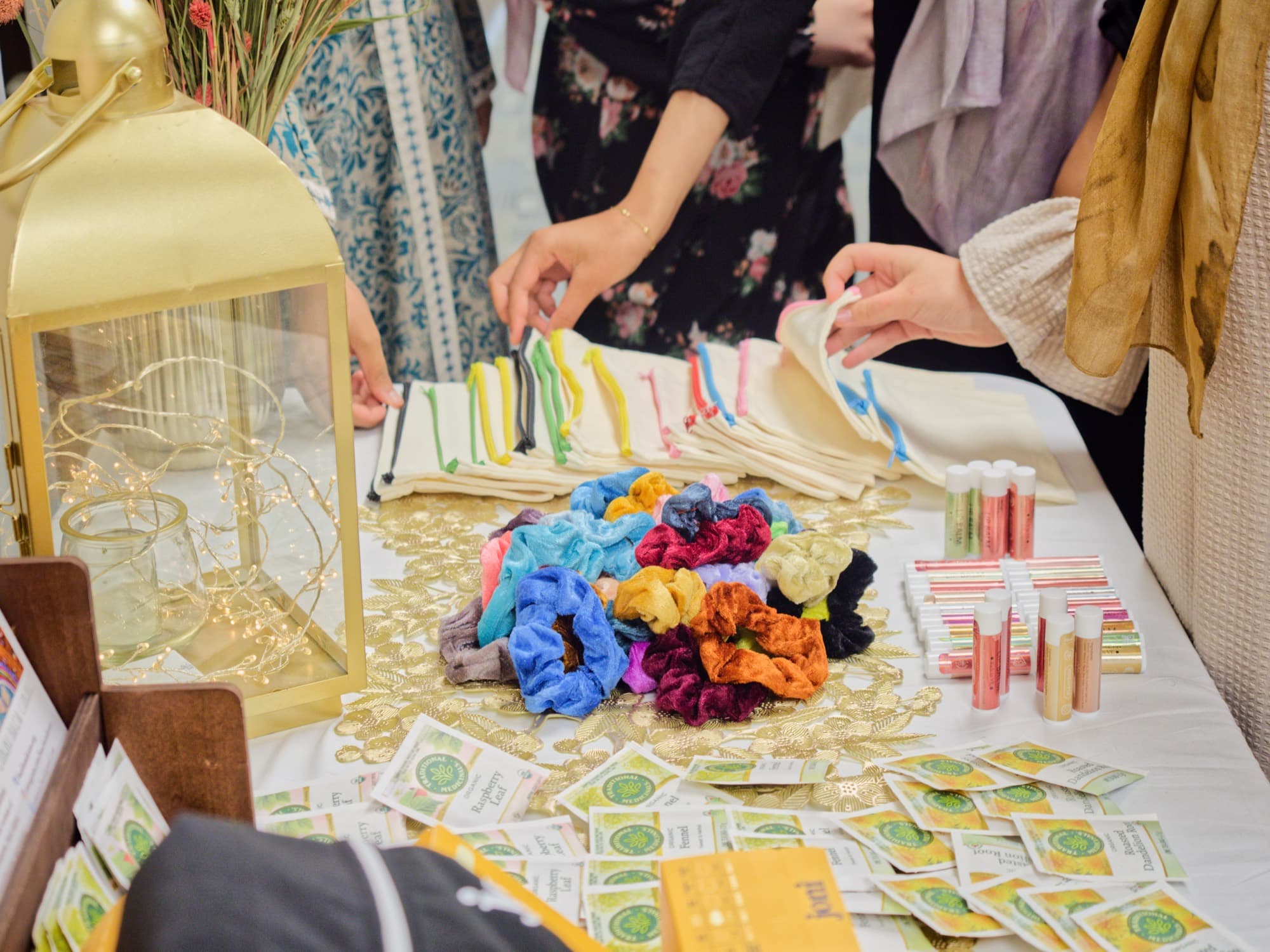 Welcome table with handmade scrunchies, tote bags, and small gifts